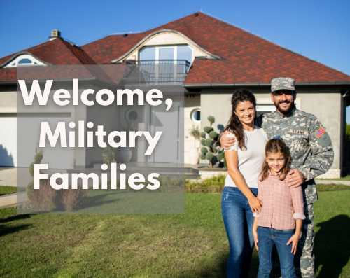 Military family stands in front of home.